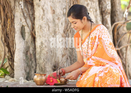 Femme adorer un arbre sacré Banque D'Images