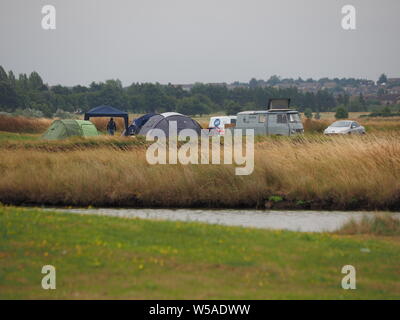 Sheerness, Kent, UK. 27 juillet, 2019. Météo France : tisser les nuages de pluie derrière les campeurs à Sheerness, Kent. Credit : James Bell/Alamy Live News Banque D'Images