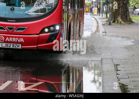 Londres, Royaume-Uni 27 Juillet 2019 - Un bus de l'eau éclabousse comme il se conduit par une inondation sur chemins verts dans le nord de Londres, causé par une forte averse dans la nuit. Credit : Dinendra Haria/Alamy Live News Banque D'Images