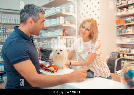 Caisse blanc duveteux donnant à son nouveau propriétaire de chien Banque D'Images