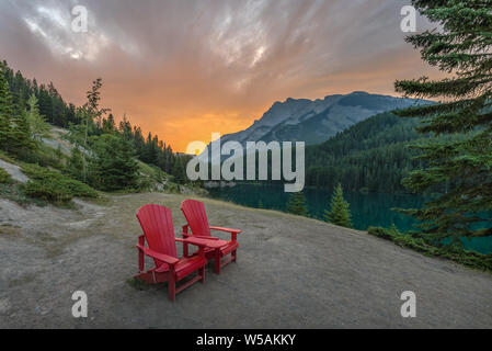 Le lever du soleil sur des chaises rouges à deux Jack Lake dans le parc national de Banff, Alberta, Canada Banque D'Images