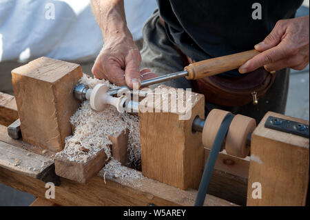 Un artisan sculpte un morceau de bois à l'aide d'une dérouleuse manuelle Banque D'Images