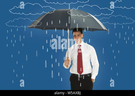 Businessman holding an umbrella and smiling Stock Photo