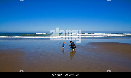 Une mère et son jeune fils jouer sur une plage de sable sur la côte du Pacifique de l'Oregon, près de la ville de Lincoln City, Oregon. Banque D'Images
