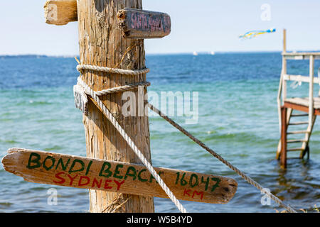 Multicolore en bois et panneau de circulation voyage qui pointe de la Suède vers des endroits à travers le monde et de dire leur distance en miles Banque D'Images