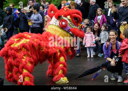 Dragon chinois rouge devant une foule de personnes au Valley Gardens Carnival, Valley Gardens, Harrogate, North Yorkshire, Angleterre, ROYAUME-UNI Banque D'Images