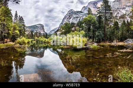 Vue panoramique sur le lac Mirror, ainsi que Tenaya Creek ; demi-dôme et entourant les crêtes des montagnes reflétées dans les eaux calmes et peu profondes du lac ; Yosemite Banque D'Images