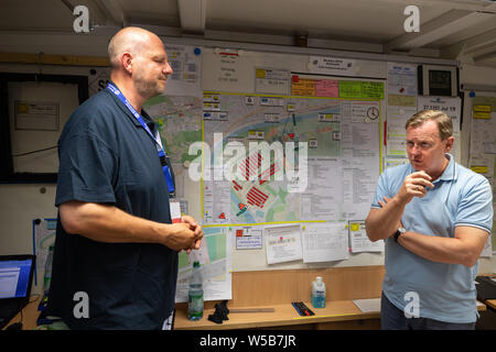 Rudolstadt, Allemagne. 27 juillet, 2019. Bodo Ramelow (gauche, droite), premier ministre de la Thuringe, parle à Oliver Tiedemann, directeur général de la THW Camp de jeunesse fédéral 2019. Autour de 5000 jeunes de toute l'Allemagne en concurrence à l'échelle fédérale des jeunes Camp de l'organisme de secours technique allemande (THW) dans les premiers secours, soins des blessures et de la transformation du bois des compétitions. Crédit : Michael Reichel/dpa/Alamy Live News Banque D'Images