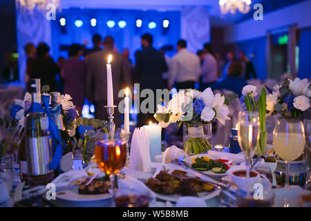 Les paramètres de table de mariage au restaurant. Les gens danser dans le fond de la table de noce. Banque D'Images