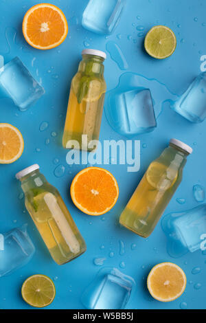 Detox d'été avec des fruits et de la limonade glaçons sur bleu Banque D'Images