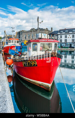 Petit bateau de pêche rouge à Sutton Harbour, anciennement connu sous le nom de pool de Sutton, port d'origine de la ville de Plymouth à l'historique quartier de Barbican. Devon. UK. Banque D'Images