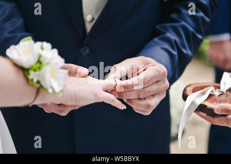 Libre de la part du marié met un anneau de mariage par correspondance sur le doigt, la cérémonie de Banque D'Images