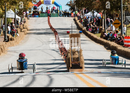 Deux concurrents franchissent la ligne d'arrivée dans leurs véhicules de boîtes à savon dans une course à la Géorgie Gravité Jeux le 3 novembre 2018 à Douglasville, GA. Banque D'Images