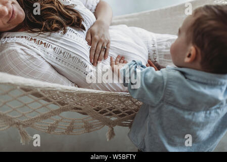 Vue rapprochée de jeune mère et bébé garçon touching pregnant belly Banque D'Images