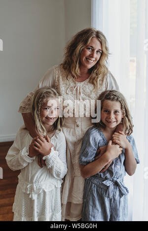 La mère et les deux filles debout dans narual studio lumière smiling Banque D'Images