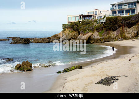 Laguna Beach, Californie / USA - Mars 10, 2019 : jeune femme de marcher seul sur une plage déserte le matin. Met l'échelle de la nature contre les gens. Banque D'Images