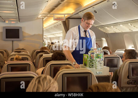 Saint-pétersbourg Vol - Burgas - 24 juin 2019 : l'intendant de la compagnie Iraero sert des passagers sur le vol charter, propose des rafraîchissements Banque D'Images