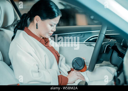 Woman cleaning a renversé du café avec un linge. Banque D'Images