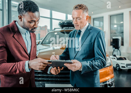 Businessman la signature d'un contrat de l'achat d'une voiture. Banque D'Images