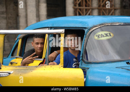 Deux jeunes beaux garçons cubaine dans un taxi cubain dégagent une Thumbs up Banque D'Images