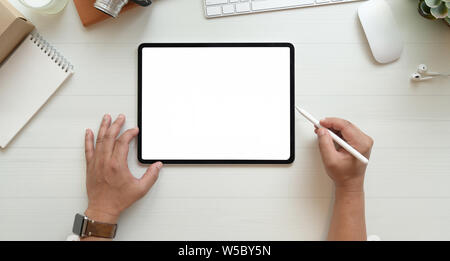 Vue rapprochée de mains du photographe l'édition d'images sur l'écran vide comprimé sur table en bois blanc, vue supérieure avec copie espace Banque D'Images