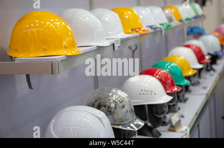 Variété de couleurs des casques de sécurité sur une étagère de magasin-entrepôt Banque D'Images