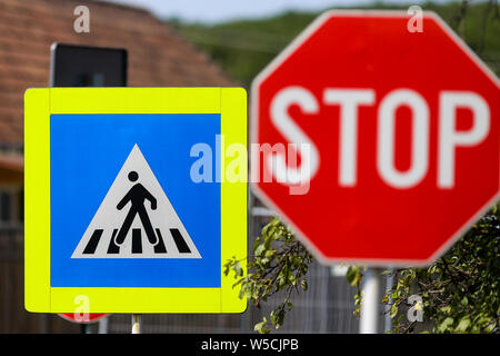 Arrêter et passage piétons signer l'un à côté de l'autre sur une rue Banque D'Images