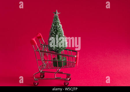 Babiole petit arbre de Noël dans un panier sur un fond rose, noël et nouvel an carte de souhaits avec copie espace Banque D'Images