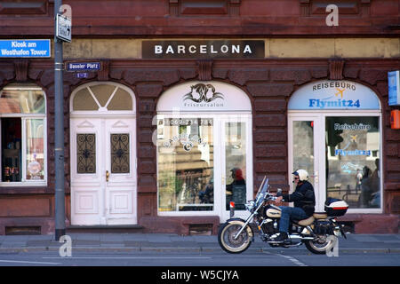 Francfort, Allemagne - Juillet 06, 2019 : un motocycliste en face de la boutique de coiffeur Barcelone à la place de Bâle, 06 juillet 2019 à Francfort. Banque D'Images