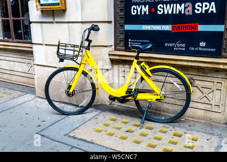 Hire Scheme jaune dockless ofo location garée dans la rue, Londres, UK Banque D'Images