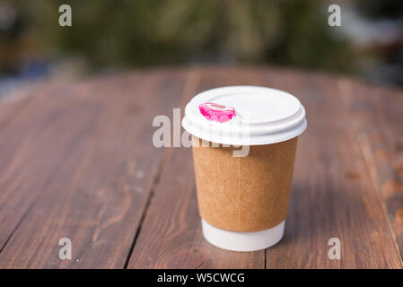 Tasses à café jetables avec marque de rouge à lèvres. Sur la table en bois. Banque D'Images