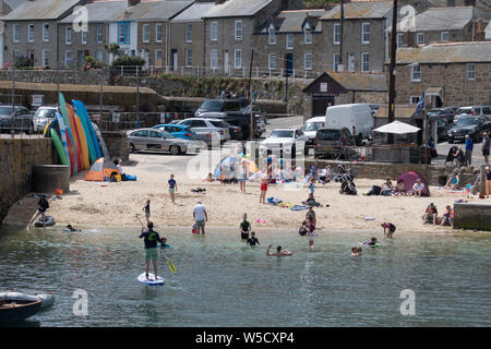 Mousehole, Cornwall, UK. 28 juillet 2019. Météo britannique. Les vacanciers étaient sur la plage à l'eau et dans l'eau autour de Mousehole Harbour aujourd'hui, alors que le beau temps a continué . Prévision pour le début de la semaine prochaine est la pluie. Simon crédit Maycock / Alamy Live News. Banque D'Images