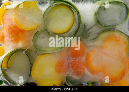 Contexte et la peau douce de szucchini dans ice cube avec des bulles d'air Banque D'Images