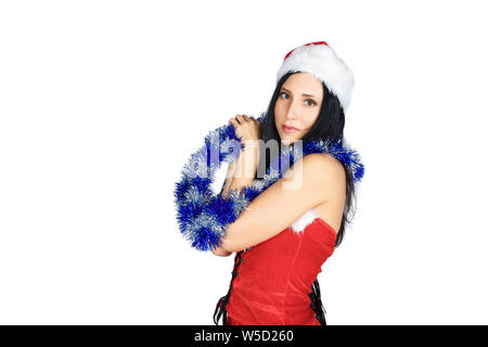 Belle fille de costume père noël tenant des branches d'arbre sur fond blanc. Banque D'Images