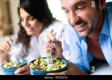 Cheerful young couple having breakfast in bed Banque D'Images