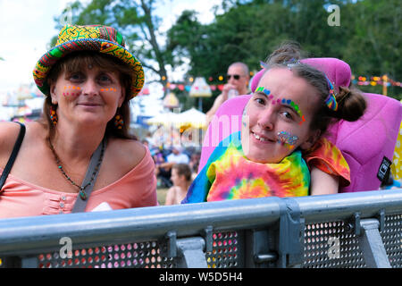 Crique de Lulworth, Dorset, UK. 28 juillet 2019. Mère avec sa fille handicapée en fauteuil roulant portant tie dye shirt et des paillettes sur le visage regardant E17 en live sur scène, Camp Bestival, Lulworth, dans le Dorset. Fletcher-Park Crédit : Dawn/Alamy Live News Crédit : Dawn/Fletcher-Park Alamy Live News Banque D'Images