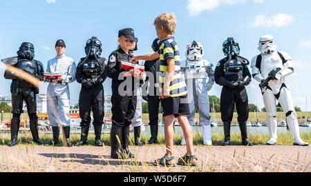 Wilhelmshaven, Allemagne. 28 juillet, 2019. Luka Rudolph (r) déclenche deux euros dans l'économie de bateau Ellen le jour de la mer sauvetage sauveteurs de la Société allemande pour le sauvetage des naufragés, qui recueille des fonds pour la DGzRS avec des stormtroopers. Credit : Mohssen Assanimoghaddam/dpa/Alamy Live News Banque D'Images