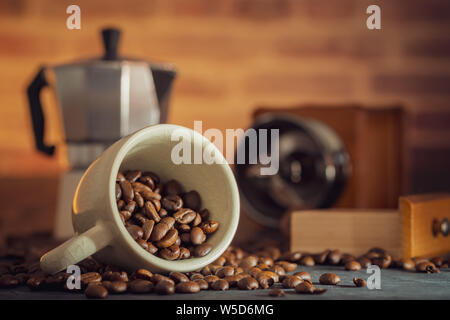 Grain de café dans la tasse blanche et un moulin à café sur table en bois. Petit-déjeuner ou le café concept de temps en matinée. Banque D'Images