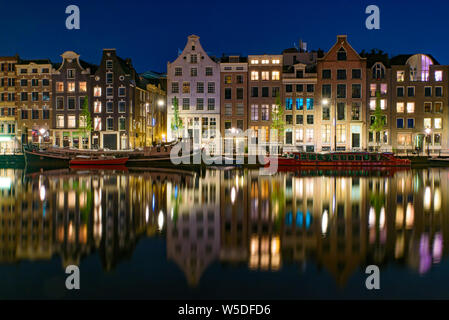 La réflexion des bâtiments le long du canal de nuit à Amsterdam, Pays-Bas Banque D'Images