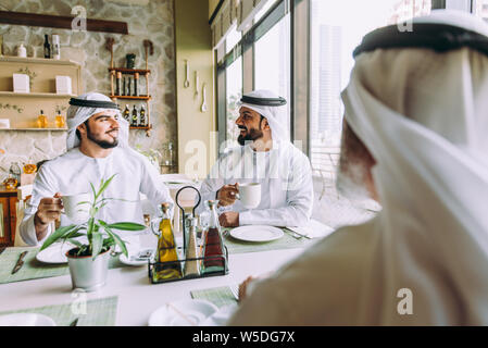 Trois hommes d'affaires ayant un plateau à Dubaï portant des vêtements traditionnels emirati Banque D'Images