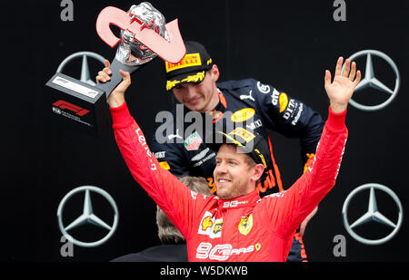 Hockenheim, Allemagne. 28 juillet, 2019. Sport : Championnat du Monde de Formule 1, Grand Prix d'Allemagne. Sebastien Vettel de Allemagne de Team Scuderia Ferrari cheers sur sa deuxième place, derrière lui le gagnant, Max Verstappen des Pays-Bas de l'Aston Martin de l'équipe Red Bull Racing. Crédit : Jan Woitas/dpa-Zentralbild/dpa/Alamy Live News Banque D'Images