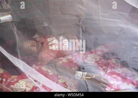 Dhaka, Bangladesh. 28 juillet 2019. Un homme recouvert d'une moustiquaire souffre de fièvre dengue qu'il reçoit le traitement dans le 'Shaheed Suhrawardy' collègue médical hôpital de Dhaka, Bangladesh, le 28 juillet 2019. La dengue a pris un virage sévère cette année avec un total de 10 528 personnes infectées avec la maladie transmise par les moustiques jusqu'à présent. C'est le nombre record de patients sont infectés par la maladie au cours des 18 dernières années au Bangladesh, selon les données de la Direction générale de la santé publique. Credit : ZUMA Press, Inc./Alamy Live News Banque D'Images