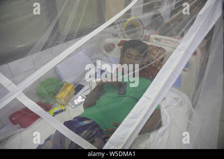 Dhaka, Bangladesh. 28 juillet 2019. Un homme recouvert d'une moustiquaire souffre de fièvre dengue qu'il reçoit le traitement dans le 'Shaheed Suhrawardy' collègue médical hôpital de Dhaka, Bangladesh, le 28 juillet 2019. La dengue a pris un virage sévère cette année avec un total de 10 528 personnes infectées avec la maladie transmise par les moustiques jusqu'à présent. C'est le nombre record de patients sont infectés par la maladie au cours des 18 dernières années au Bangladesh, selon les données de la Direction générale de la santé publique. Credit : ZUMA Press, Inc./Alamy Live News Banque D'Images