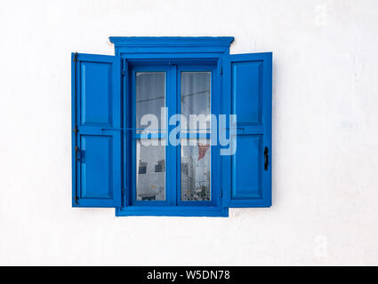 Fenêtre avec les volets ouverts et mur blanc de maison grecque à Amorgos, en Grèce. Banque D'Images