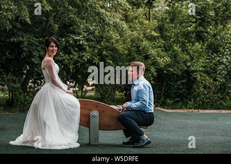 Jeunes mariés aiment passer du temps sur les balançoires. Mariage Concept, des jeunes mariés, nouvelle famille, copie de l'espace. Banque D'Images