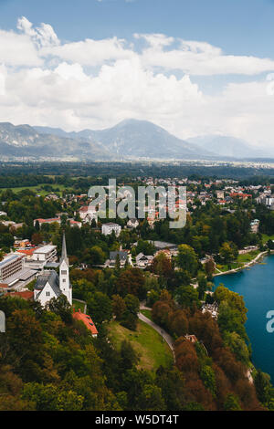 Vue aérienne de la ville de Bled, l'église paroissiale de Saint Martin, Resorts, hôtels, maisons, parcs et plages située sur la rive du lac de Bled, entouré Banque D'Images