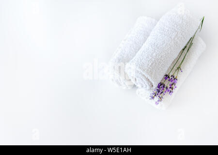 Livre blanc des serviettes propres et des fleurs de lavande sur fond blanc isolé. Banque D'Images