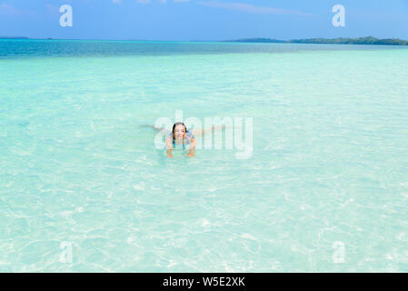 Woman swimming in turquoise de la mer des Caraïbes l'eau transparente. Plage tropicale des îles Kei (Moluques, été destination touristique en Indonésie. Banque D'Images