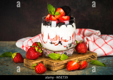 Dessert aux fraises parfait avec du yaourt et des biscuits au chocolat. Banque D'Images