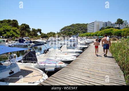 Le petit port de plaisance de monde avec de petites embarcations à Cala Galdana sur une chaude journée d'été Îles Baléares Minorque espagne Europe Banque D'Images